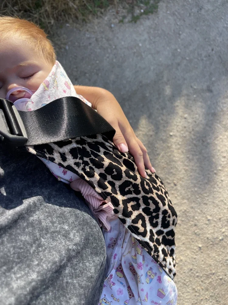 Bebê dormindo junto ao colo durante um passeio